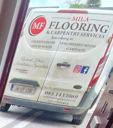 The Mila Flooring & Carpentry van, signwritten with the company name, the specialisms herringbone, solid wood, engineered wood and laminate, the phone number 085 143 3969 and 'fully insured'