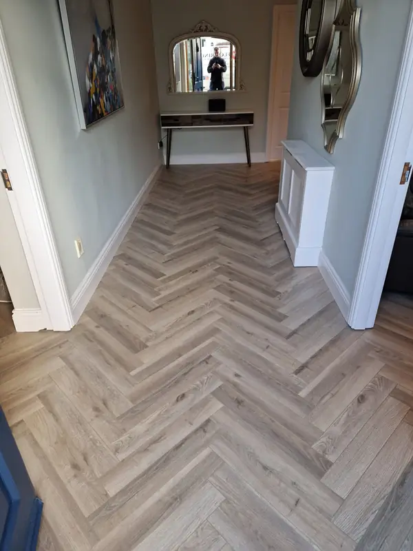 Pale oak herringbone floor in a bright entrance hallway with console table