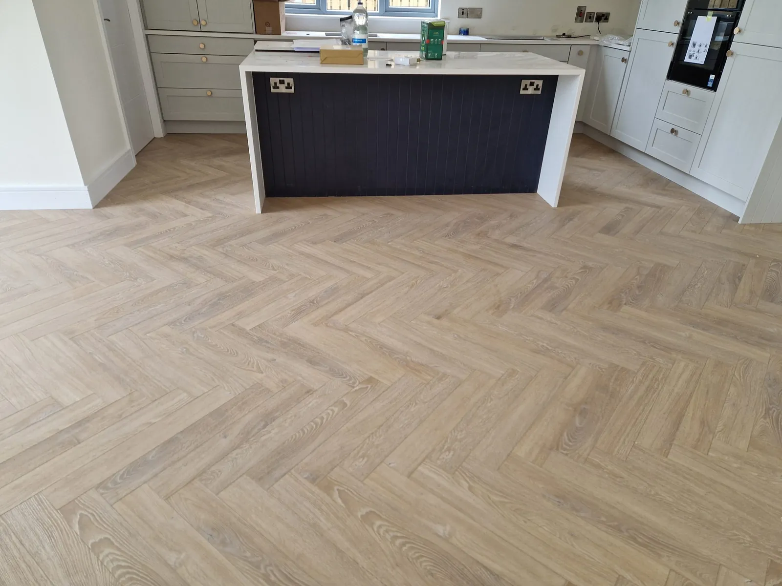Herringbone oak floor in a contemporary kitchen with a large island