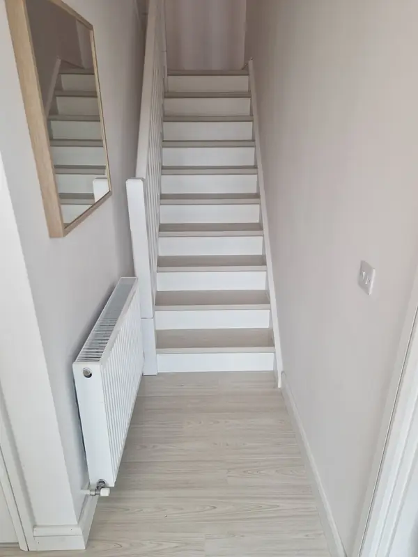 Renovated staircase with pale timber treads and painted white risers