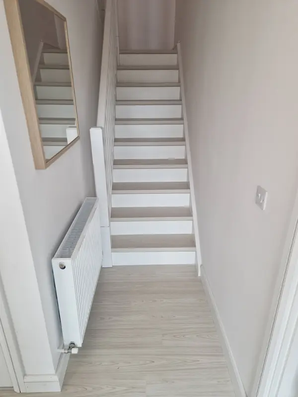 Staircase renovation showing light timber treads and clean white risers