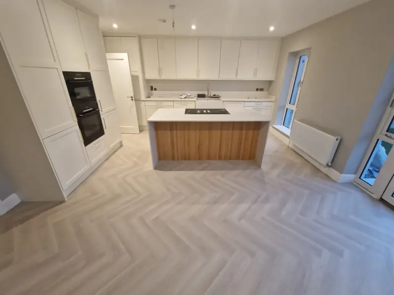 Herringbone floor in a modern kitchen with island and integrated appliances