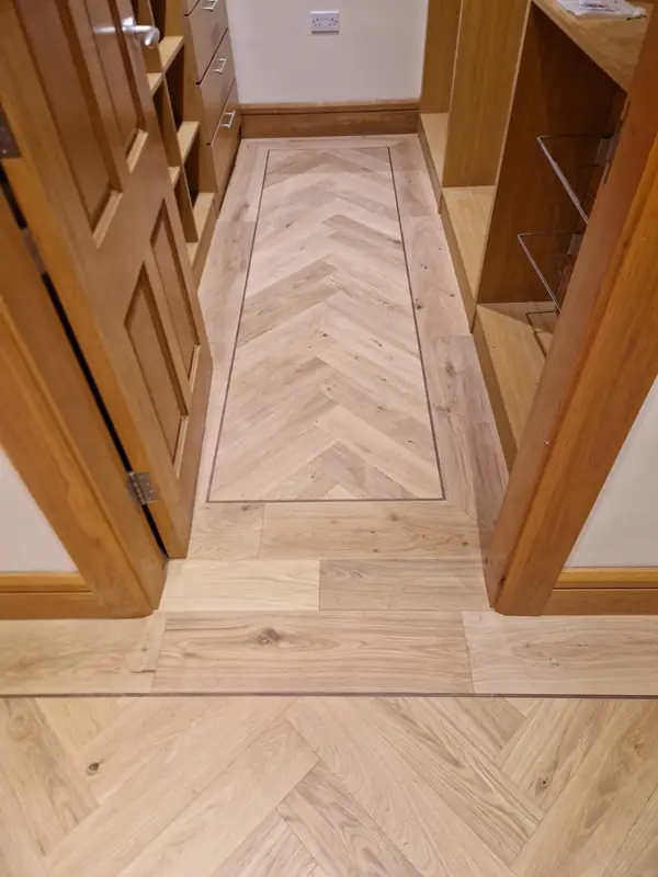 Herringbone hallway floor with contrasting border and solid oak doors