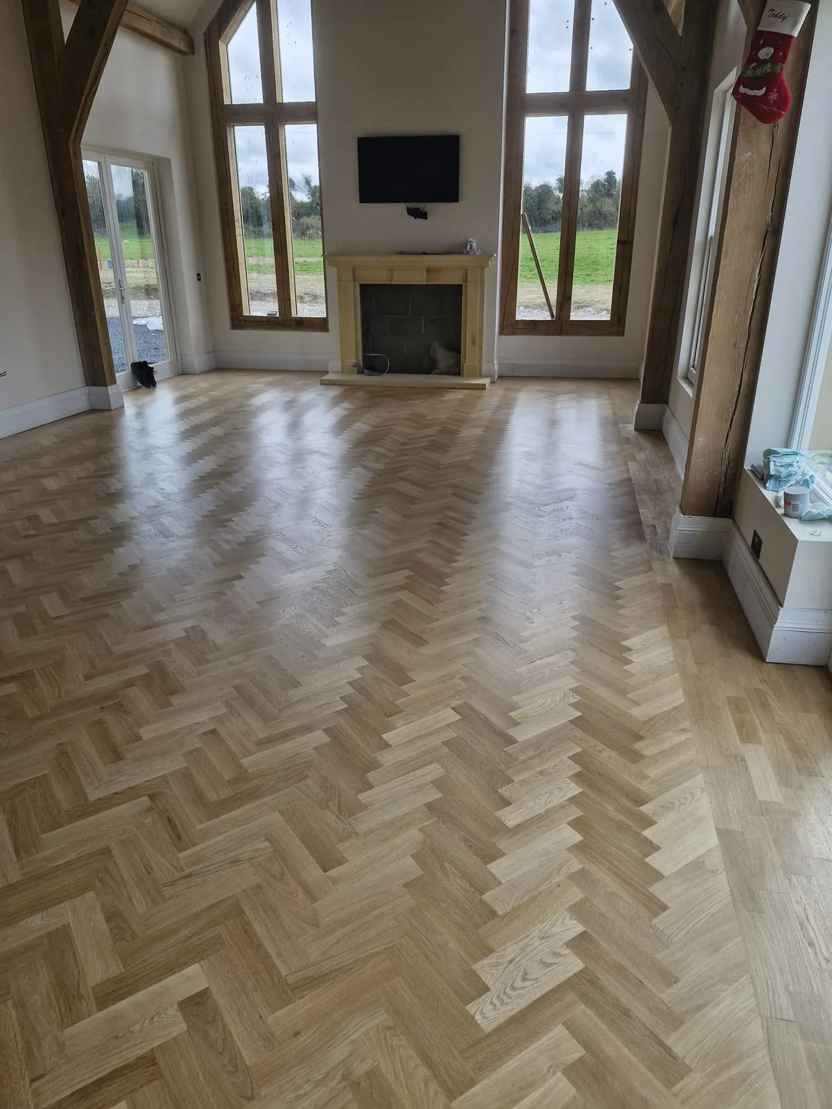 Herringbone flooring in a large vaulted living space with a feature fireplace