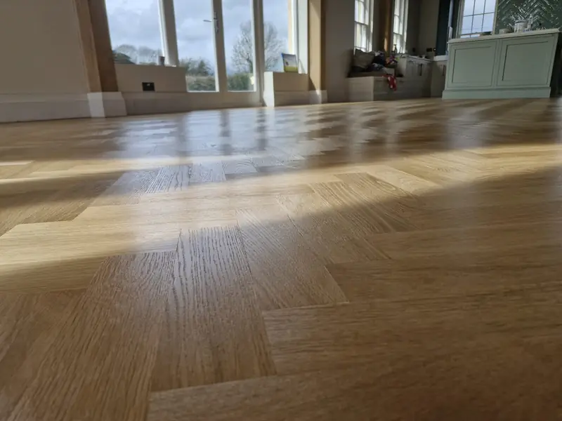 Restored timber plank flooring in a large room after sanding and sealing