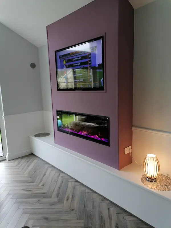 Grey herringbone LVT flooring with a modern fireplace media wall
