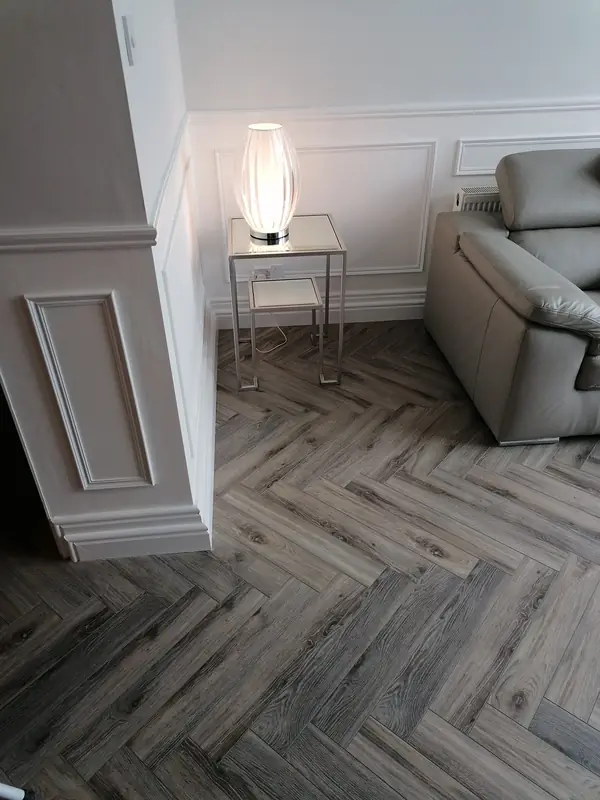 Grey-toned herringbone LVT in a panelled living room