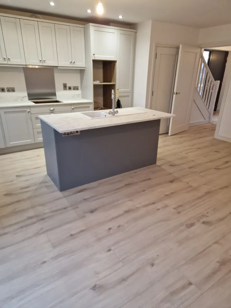 Wide plank floor through an open plan kitchen and dining area